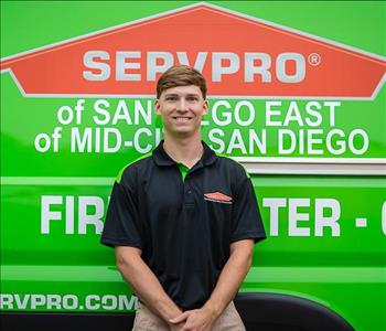 Man standing in front a green background with SERVPRO logo on it. 