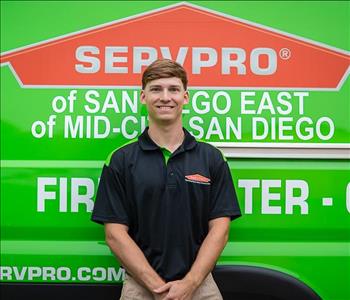 Man standing in front a green background with SERVPRO logo on it.