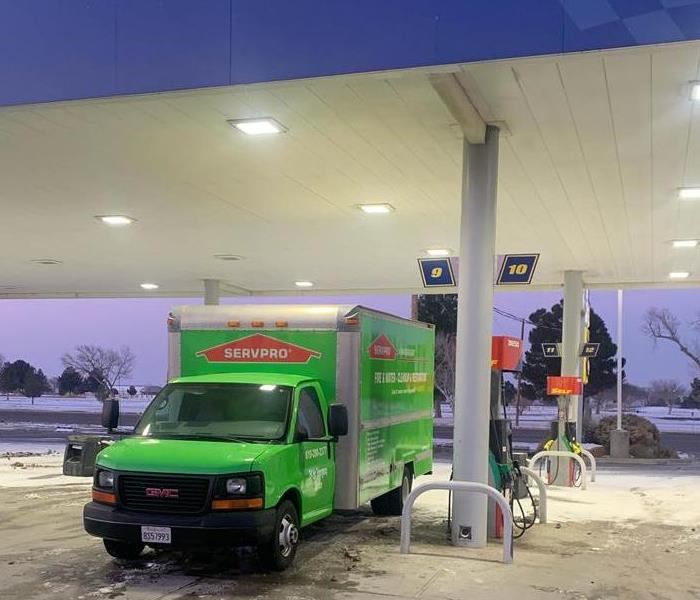 Green SERVPRO van getting gas.