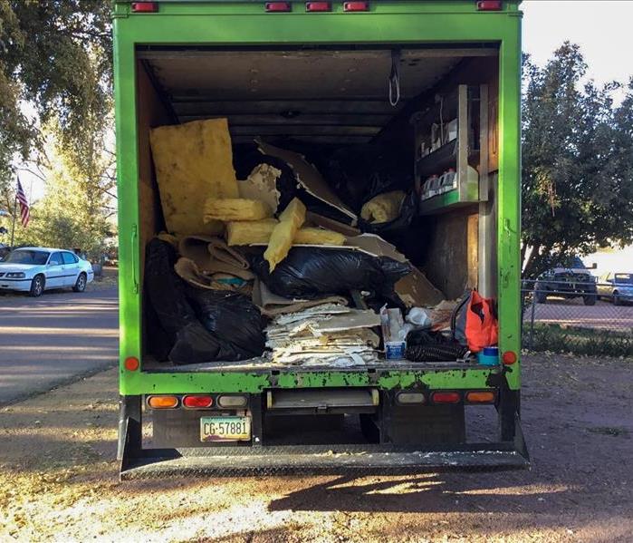 Employee on the back of a moving van. 