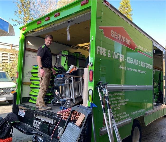 Employee on the back of a moving van. 