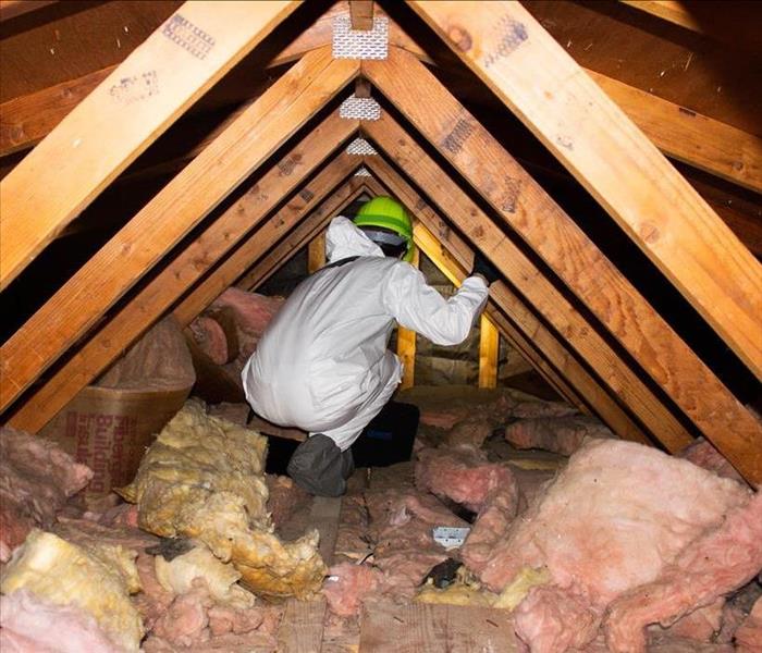 Crew member searching in the attic to find the loss