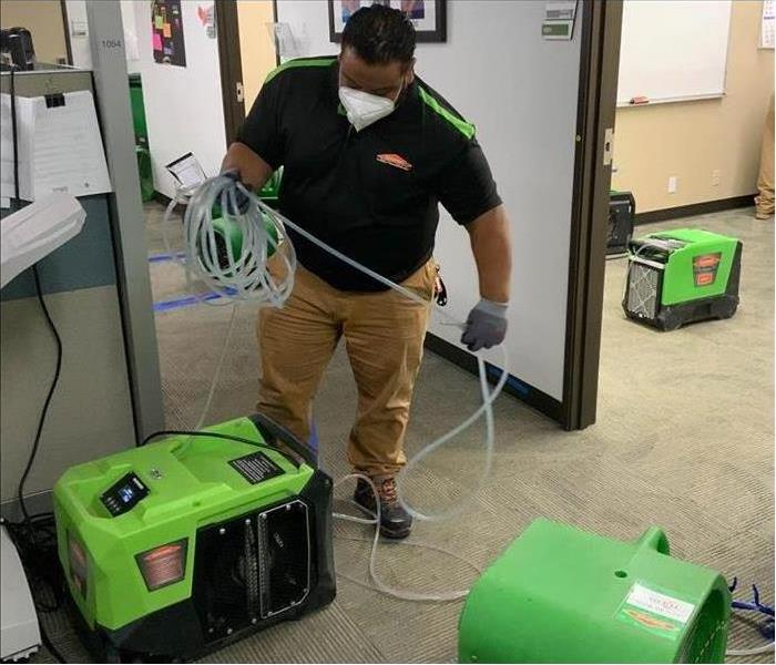 Technician setting up drying equipment in an office
