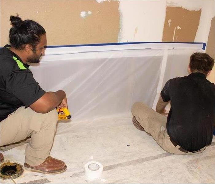 Workers of a restoration company working in a home