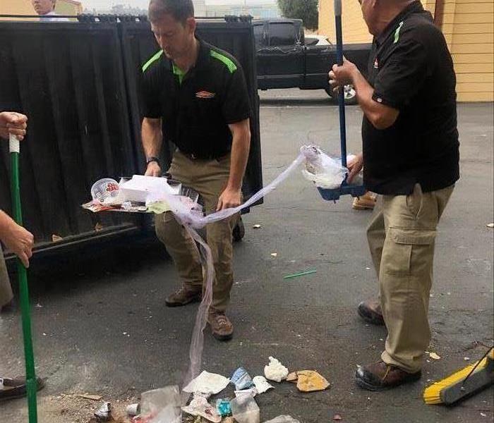 The owner of SERVPRO of San Diego cleaning up some trash.